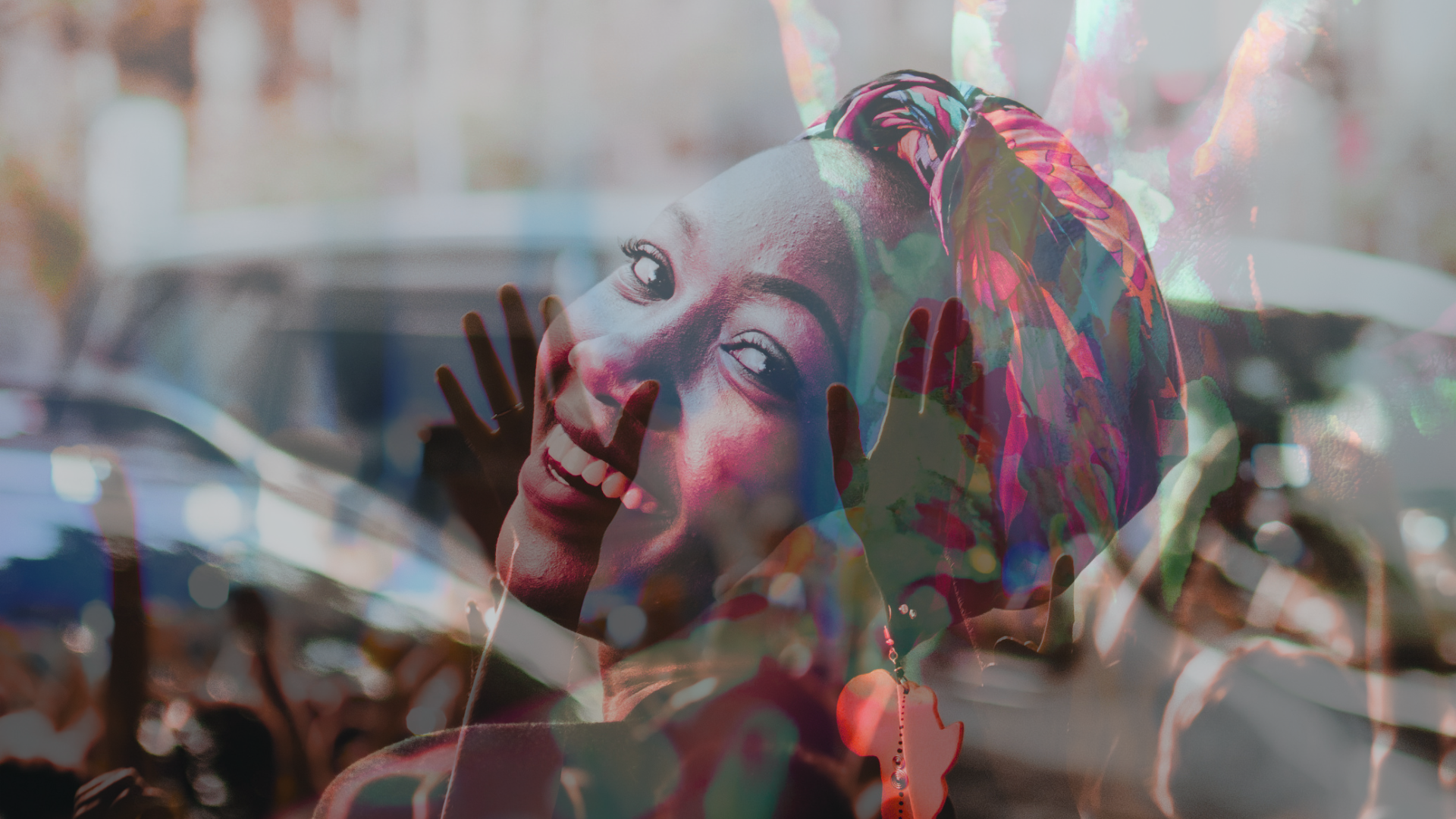 A smiling woman wearing a colorful headwrap is seen in the foreground, overlaid with an image of raised hands at a lively outdoor event, creating a vibrant and joyful atmosphere.