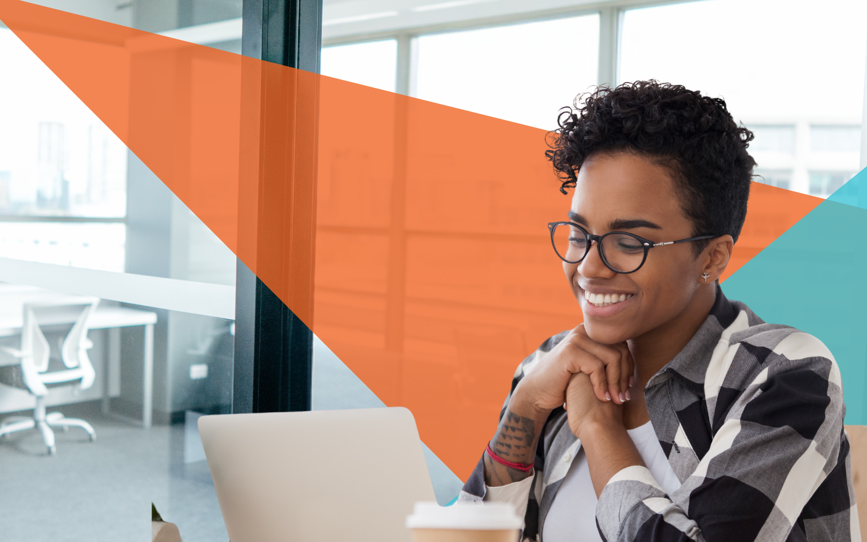 A person with short curly hair and glasses smiles while looking at a laptop in a modern office, with orange and blue geometric shapes overlaid on the background.