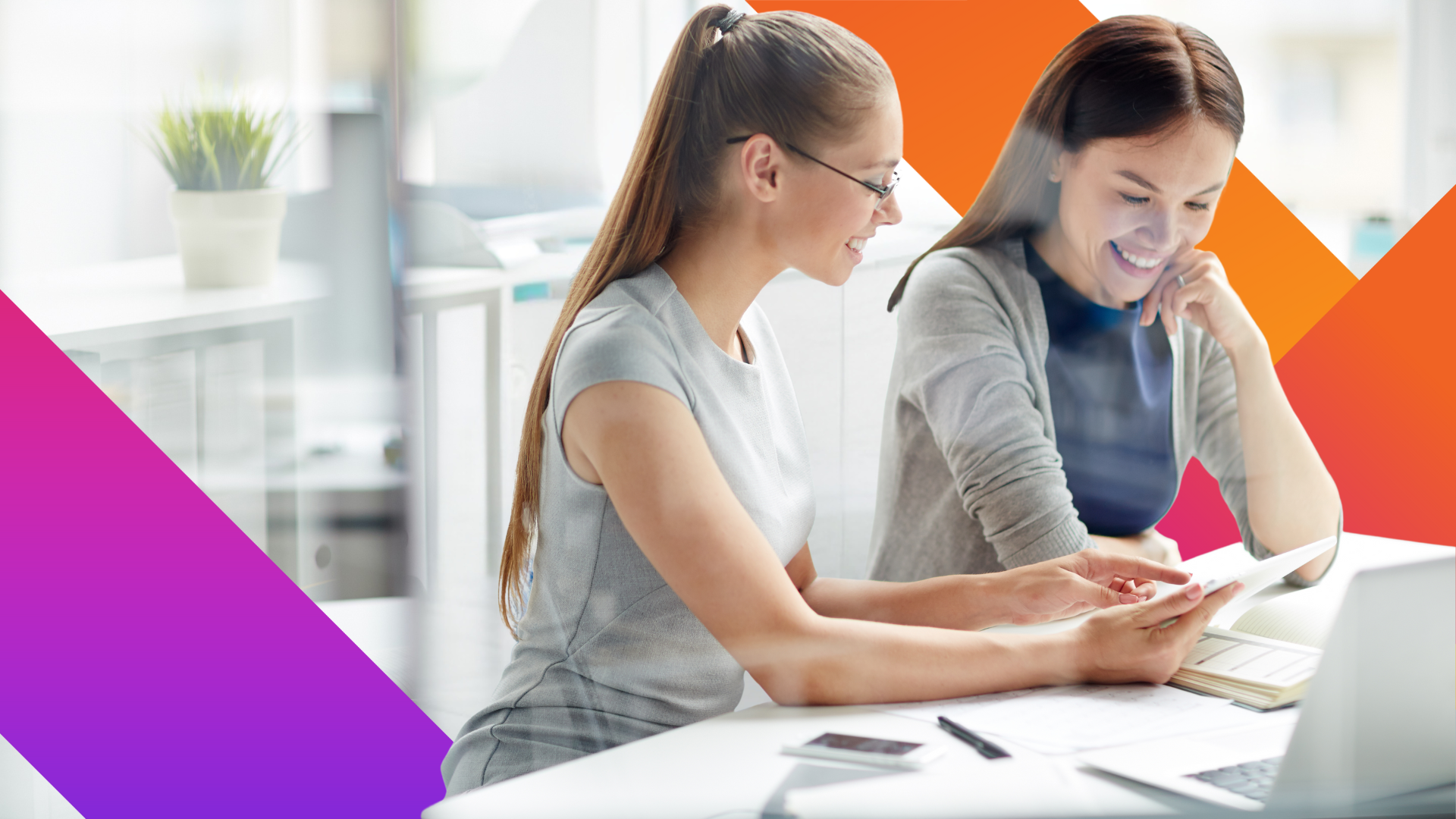 Two women sit at a desk in a bright office, smiling and looking at a document together. A laptop, notebook, and phone are on the table, and colorful geometric shapes frame the image.