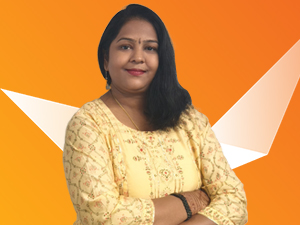 A woman with long black hair wearing a yellow patterned top stands with arms crossed, smiling against an orange background with white geometric shapes.