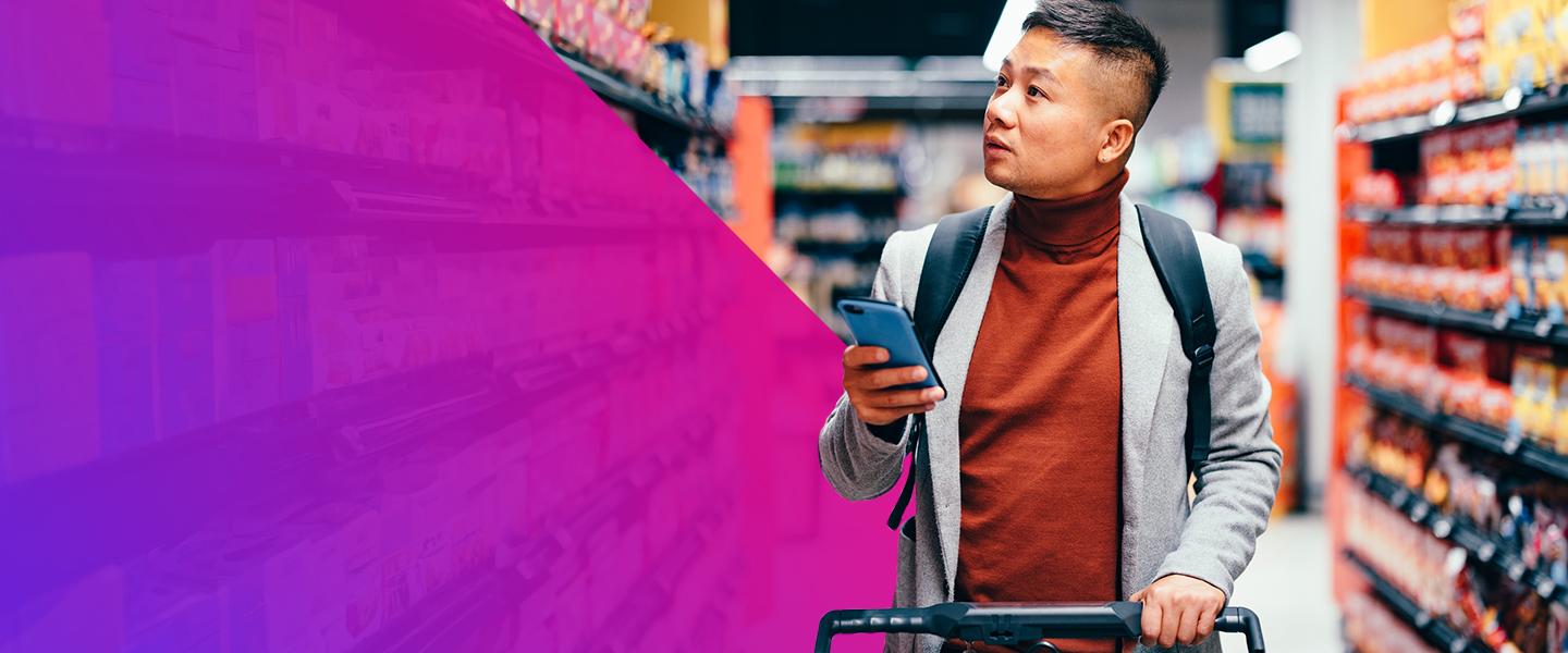 A man with a backpack pushes a shopping cart down a grocery store aisle, looking up while holding his phone. Shelves of products line the aisle, and a purple overlay covers the left side of the image.