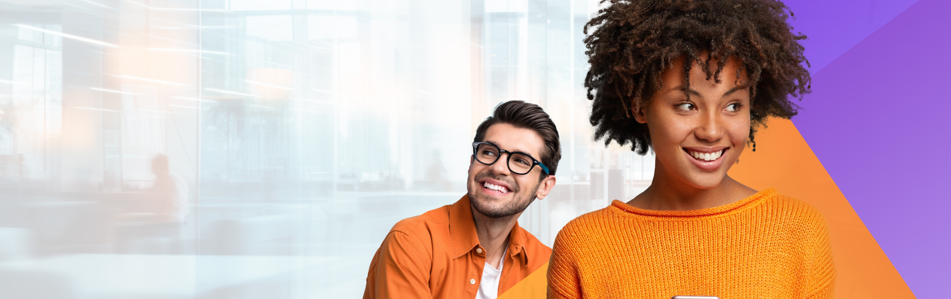 Smiling man wearing glasses and orange shirt looks to the side, standing next to a smiling woman with curly hair in an orange sweater, against a blurred background with abstract purple and orange shapes.