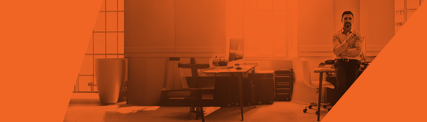 A man stands by a desk in a modern office reflecting on recognition programme maturity