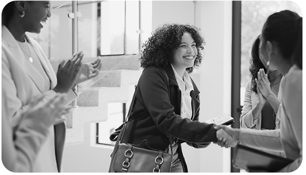 Photograph of colleagues shaking hands, representing recognition and achievement