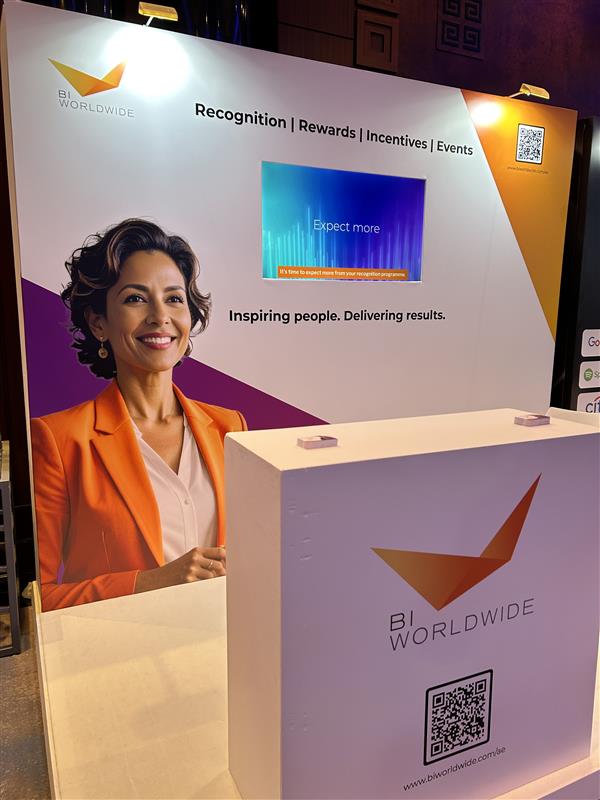 BI WORLDWIDE stand display with a smiling woman in an orange blazer, a screen reading Expect more, and text: Recognition | Rewards | Incentives | Events and Inspiring people. Delivering results.