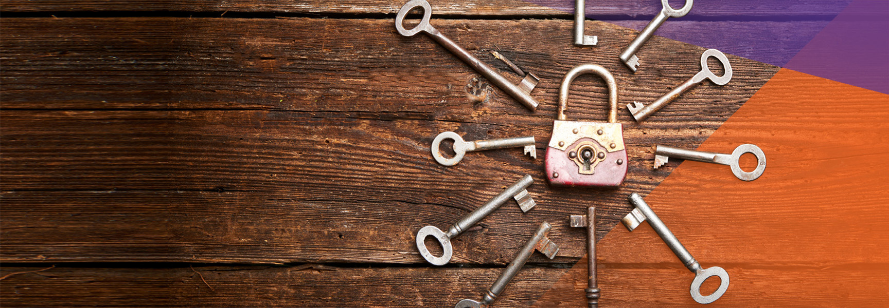 A variety of vintage keys arranged in a circle around an old padlock on a wooden surface, with a gradient of purple and orange in the top right corner.