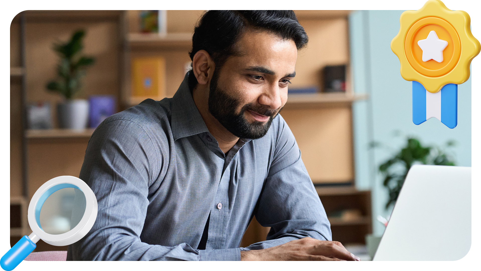 A man with a beard, wearing a gray shirt, smiles while working on a laptop at a desk. Illustrated icons of a magnifying glass and a gold ribbon with a star are overlaid on the image.