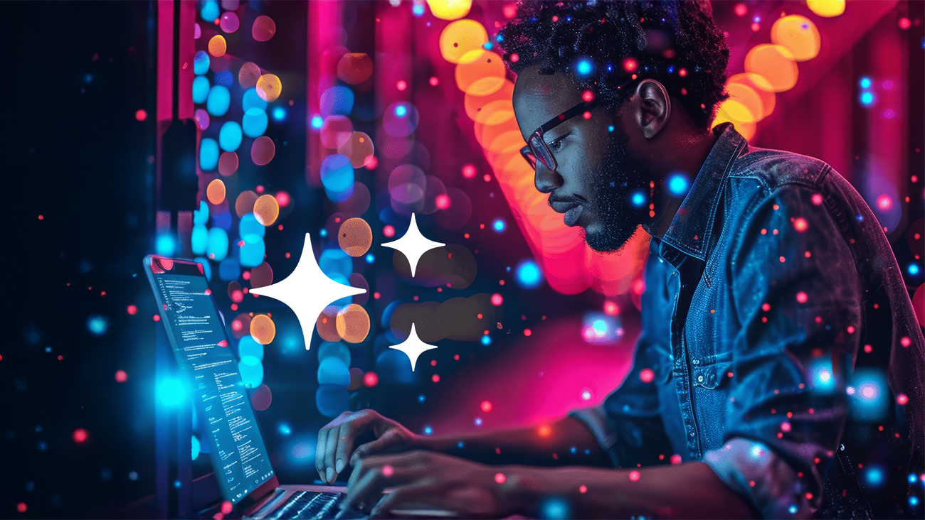 A person with glasses types on a laptop in a vibrant, neon-lit setting with colorful lights and sparkles surrounding them, creating a creative and futuristic atmosphere.