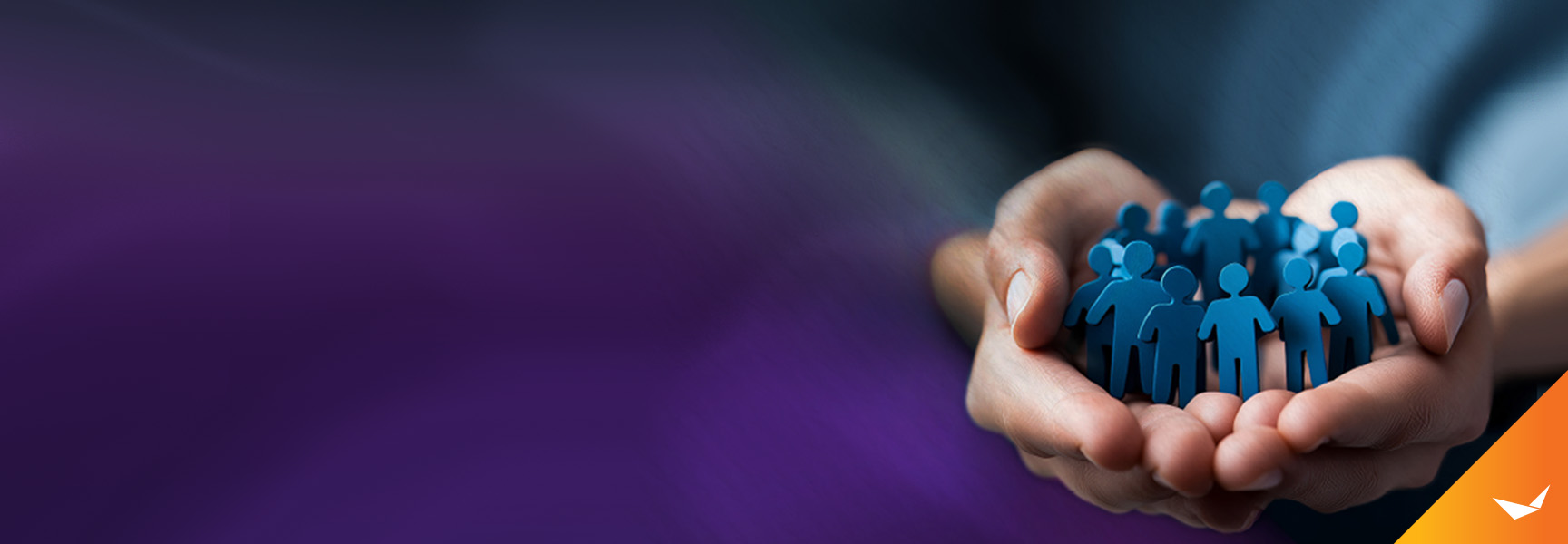 A pair of hands gently cups several blue human-shaped figures, symbolizing community or teamwork, against a blurred purple and blue background with an orange corner detail.