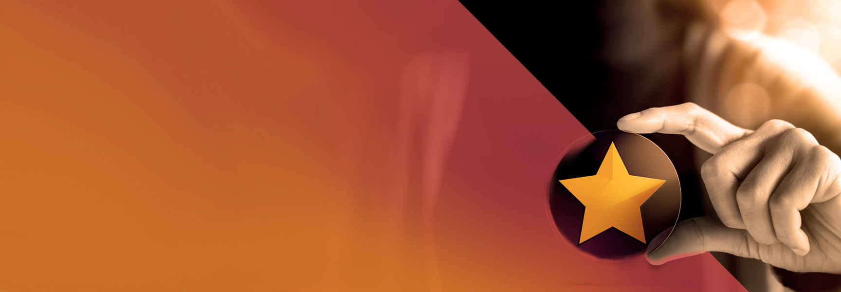 A hand holds a round black object featuring a yellow star on the right side of an abstract orange and red background, with a gradient effect and blurred lighting.