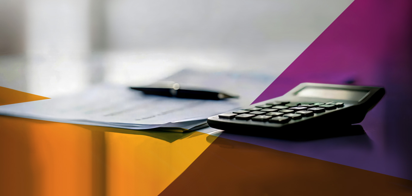 A black calculator and a pen rest on top of paperwork on a desk, with colorful geometric shapes partially overlaying the image. The background is softly blurred.